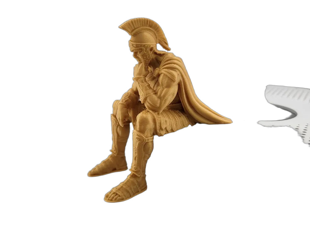 Goldene Figur des denkenden Odysseus auf einer Ablagefläche